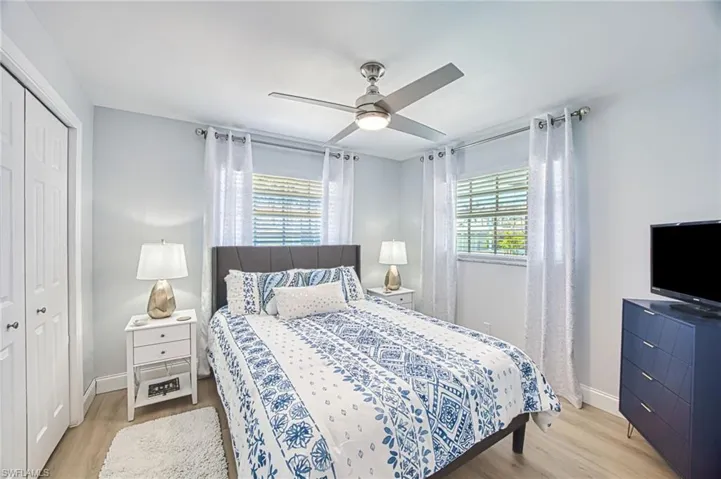 Bedroom with a closet, multiple windows, and light wood finished floors