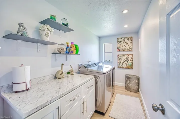 Laundry room with washer, dryer, light wood-type flooring, cabinet space and a Deep sink