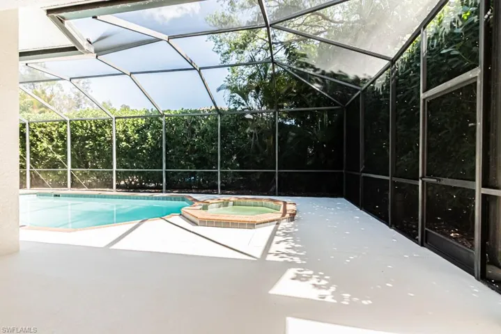 Combined pool / hot tub with a sunroom, glass enclosure, and a second smaller patio area.