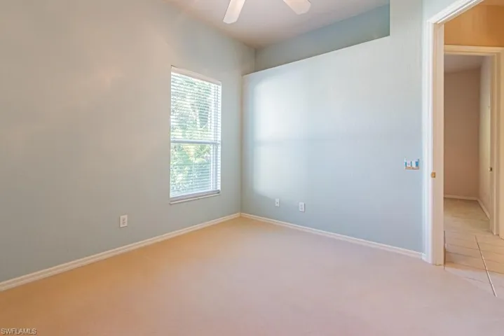 Unfurnished bedroom featuring light colored carpet and a ceiling fan.