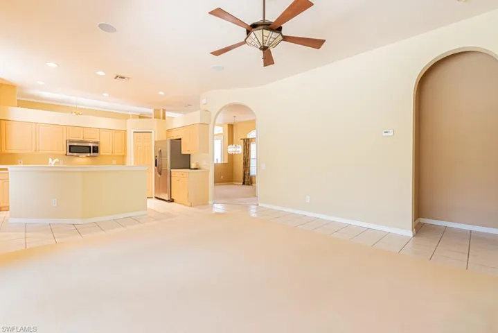 Unfurnished Family room with a ceiling fan, recessed lighting, arched walkways, and light tile patterned floors