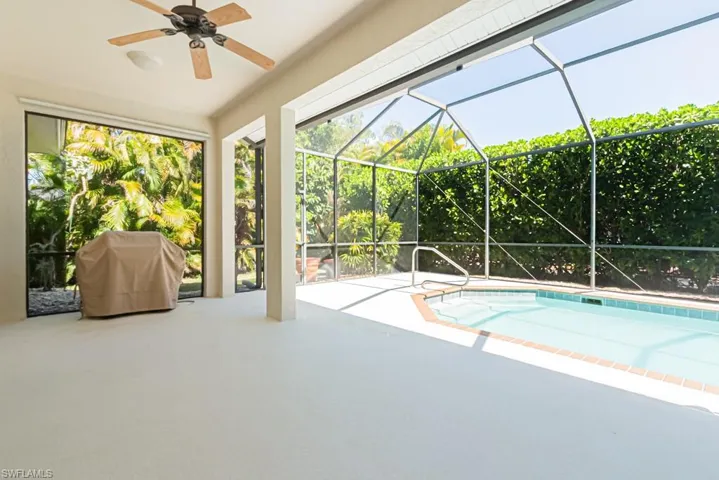 Outdoor pool featuring area for grilling, a patio area, a sunroom, and a private lanai.