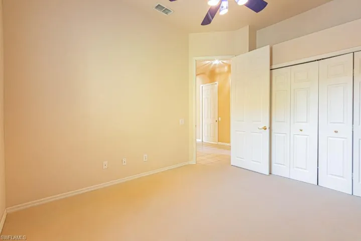 Large third bedroom featuring carpet floors, a closet, and ceiling fan- both guest bedrooms are on opposite end of the home from the primary bedroom.