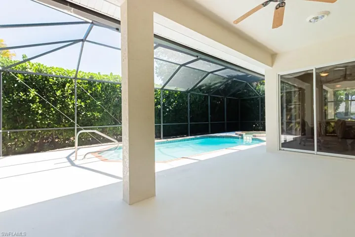Swimming pool featuring a patio area, a sunroom, and glass enclosure