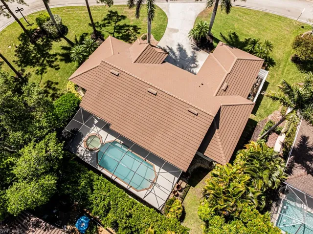 Aerial view of property and surrounding area with a pool area.  Home is located in Lely Country Club.