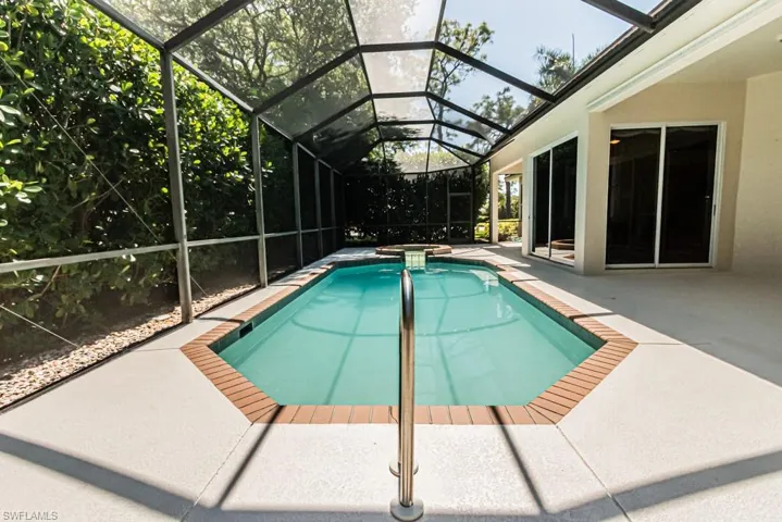 Combined pool / hot tub featuring a patio, glass enclosure, and a sunroom