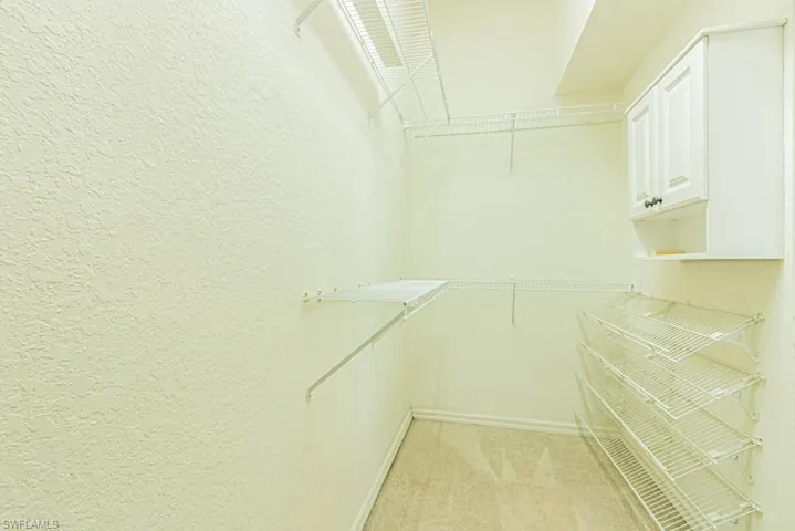 Walk in closet featuring light carpet
