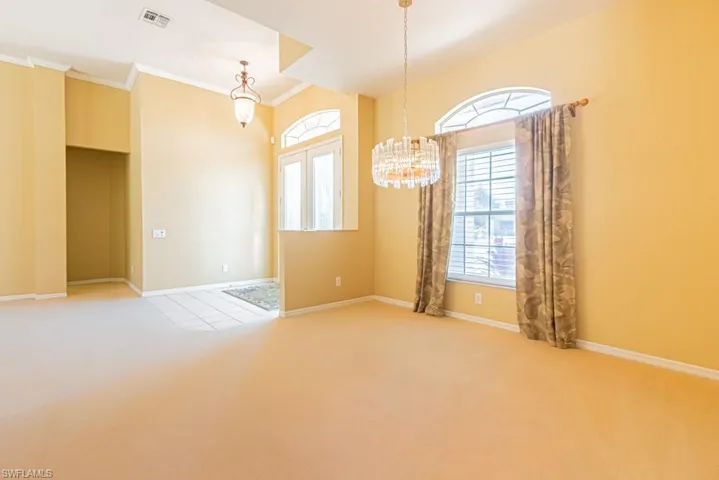 Dining room with suspended chandelier lighting and large window for natural sunlight.