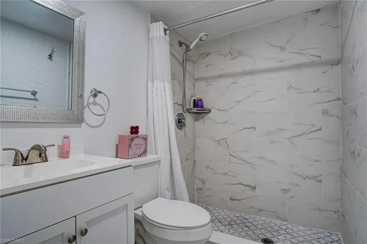 Bathroom featuring vanity, a shower with curtain, and toilet