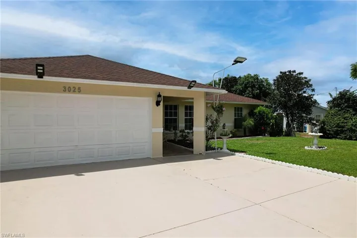 Single story home with a garage and a front yard