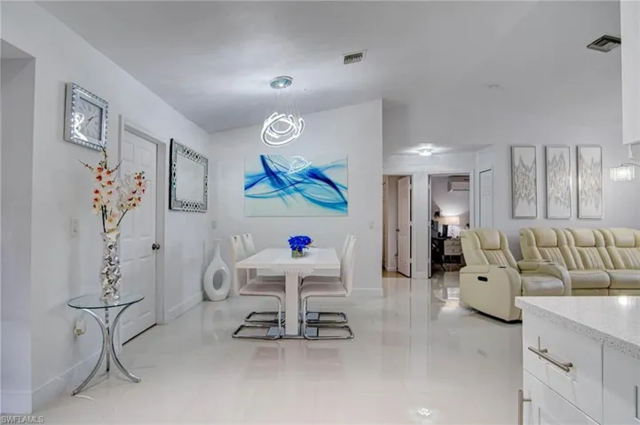 Dining space with vaulted ceiling and light tile patterned flooring