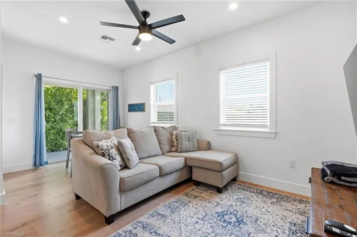 Living area featuring wood-finish flooring, recessed lighting, and a ceiling fan