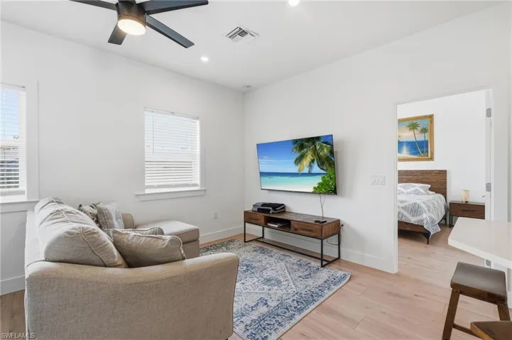 Open-concept living area featuring light wood-finish flooring, recessed lighting, and a contemporary ceiling fan