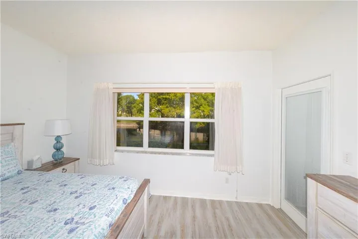 Bright room featuring a large window with multiple panes, providing natural light and a water backdrop