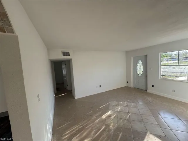 Tiled entrance foyer with visible vents and baseboards