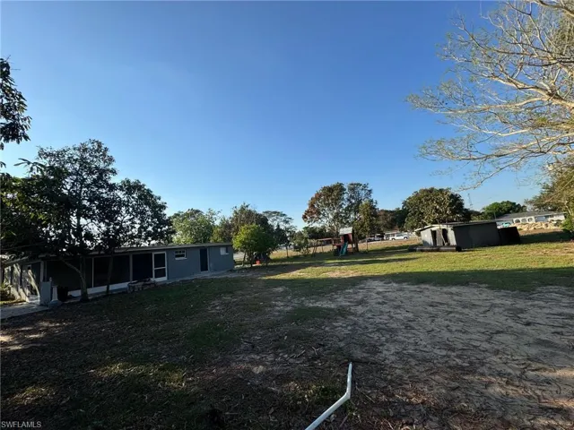 View of yard with a playground and a sunroom