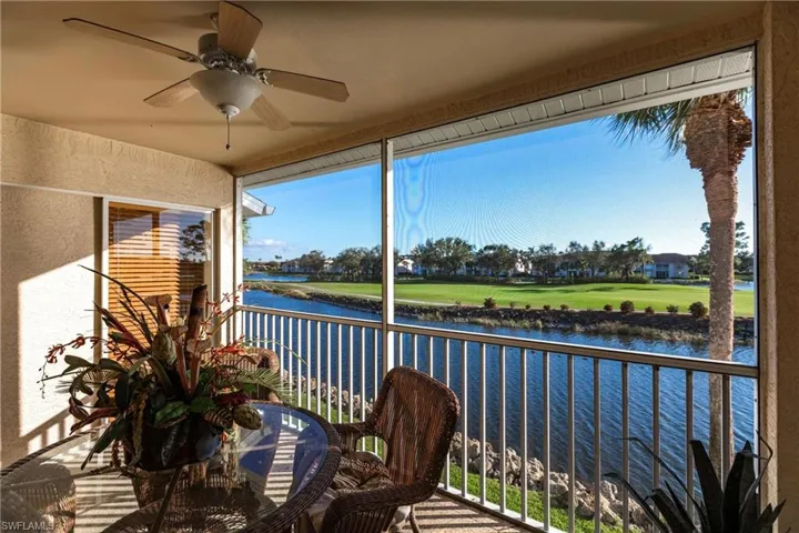 Sunroom / solarium with ceiling fan and a water view