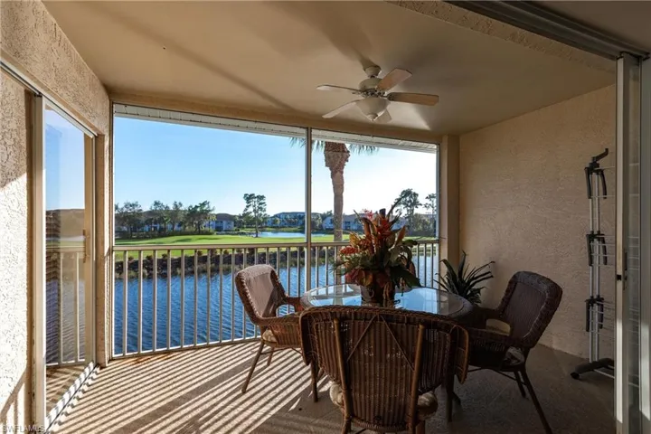 Sunroom featuring a water view and ceiling fan