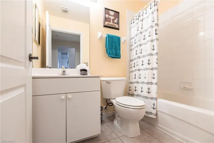 Full bathroom with tile patterned flooring, vanity, toilet, and shower / tub combo