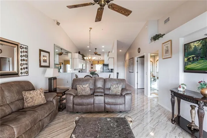 Living room featuring high vaulted ceiling and ceiling fan