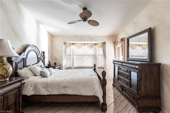 Bedroom with ceiling fan and multiple windows