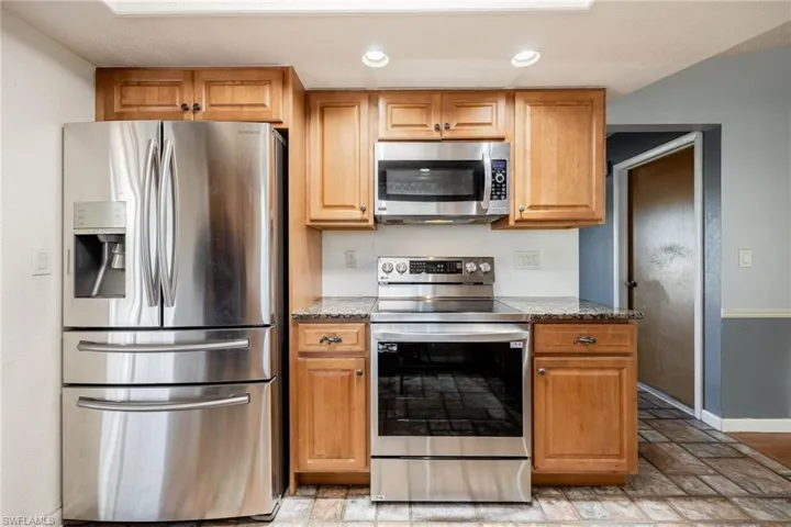 Kitchen with stainless steel appliances and stone counters