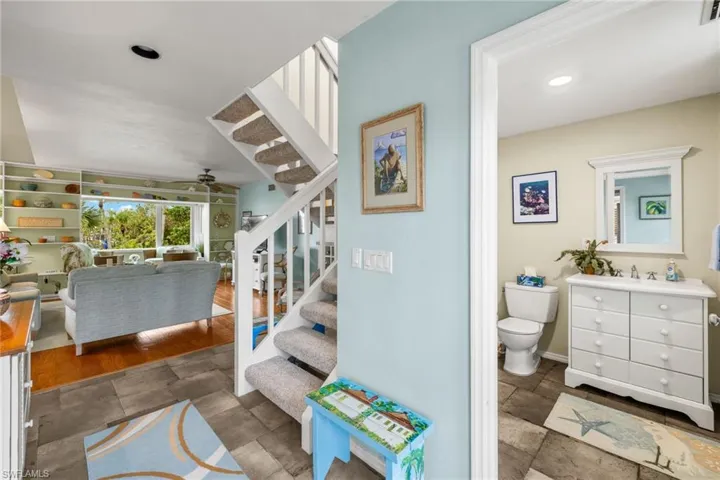Stairway with hardwood / wood-style flooring and ceiling fan