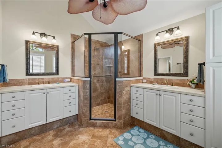 Bathroom featuring tile walls, an enclosed shower, and vanity