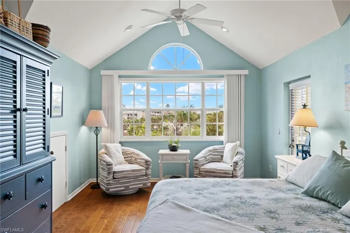 Bedroom featuring dark wood-type flooring, vaulted ceiling, and ceiling fan