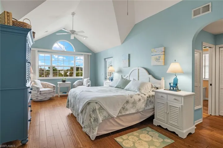 Bedroom with ceiling fan, dark hardwood / wood-style floors, and vaulted ceiling