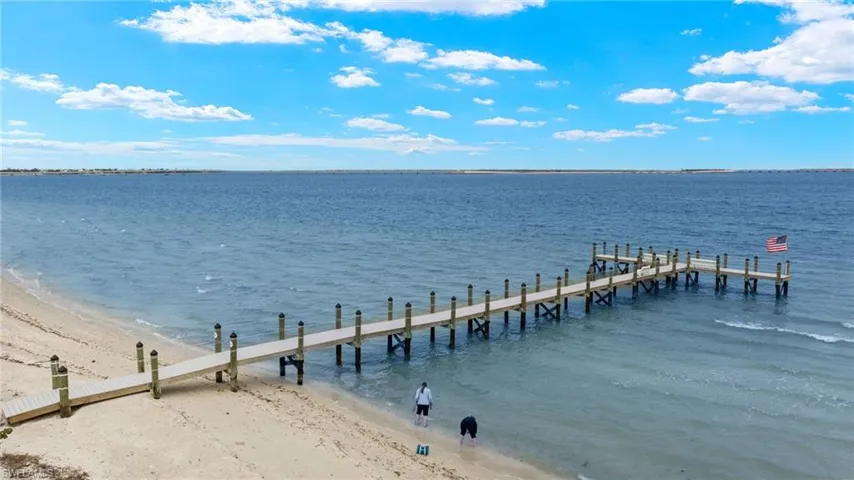View of dock featuring a water view and a view of the beach