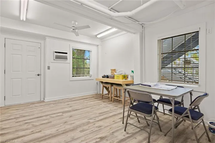 Dining room with a wall mounted air conditioner, a healthy amount of sunlight, light hardwood / wood-style floors, and ceiling fan