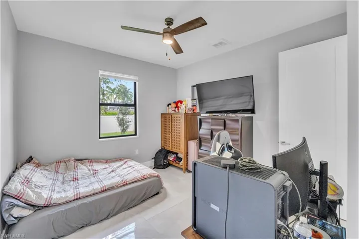 Tiled bedroom featuring ceiling fan