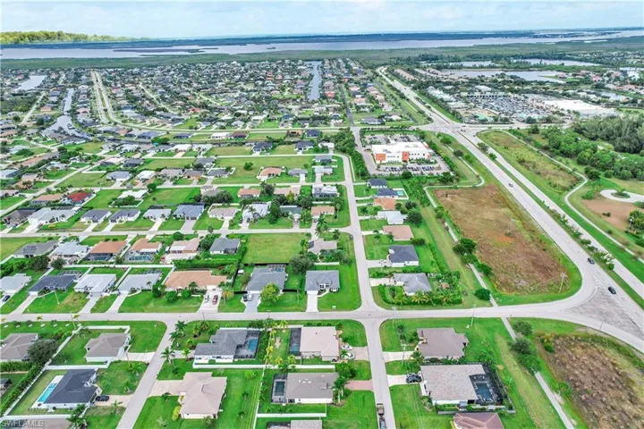 Aerial view of property and surrounding area with nearby suburban area