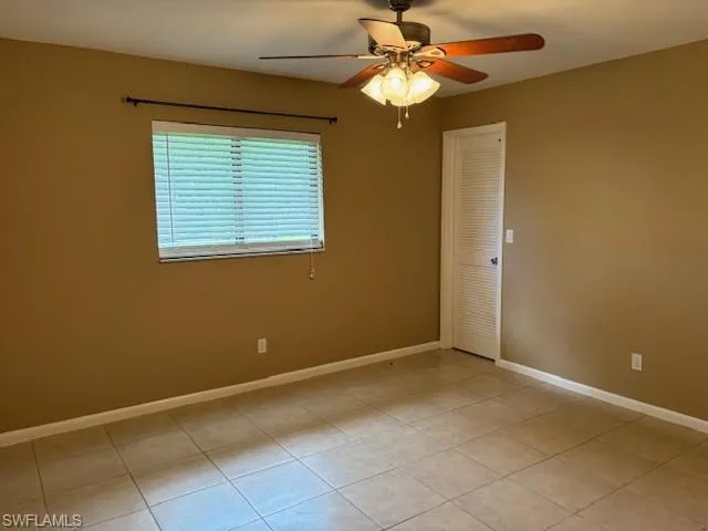 Tiled empty room with ceiling fan