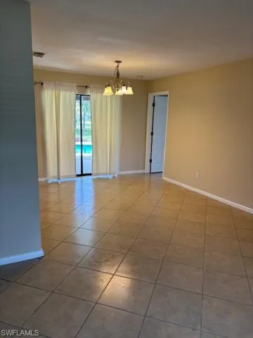Tiled empty room with a chandelier