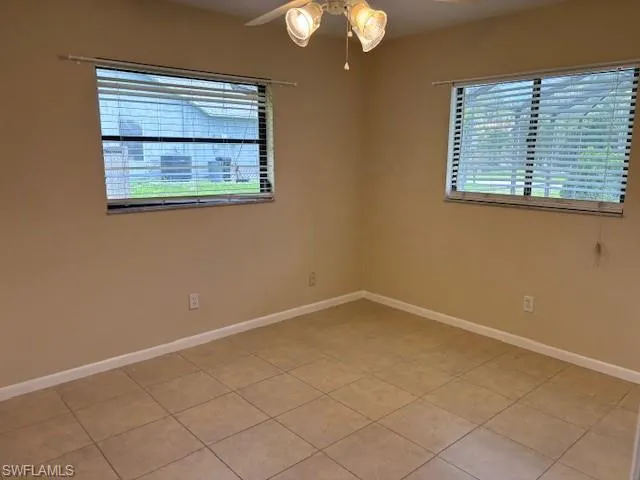 Empty room featuring tile patterned flooring and ceiling fan