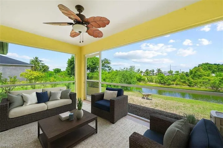 Sunroom featuring a water view, plenty of natural light, and view of scattered trees