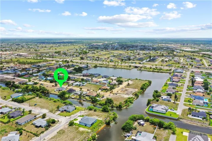 Aerial view of property and surrounding area with a nearby body of water and nearby suburban area