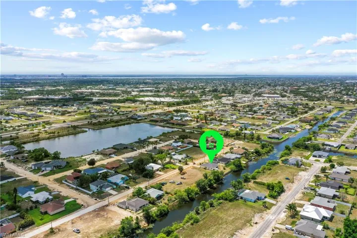 Aerial view of property and surrounding area featuring a large body of water and nearby suburban area