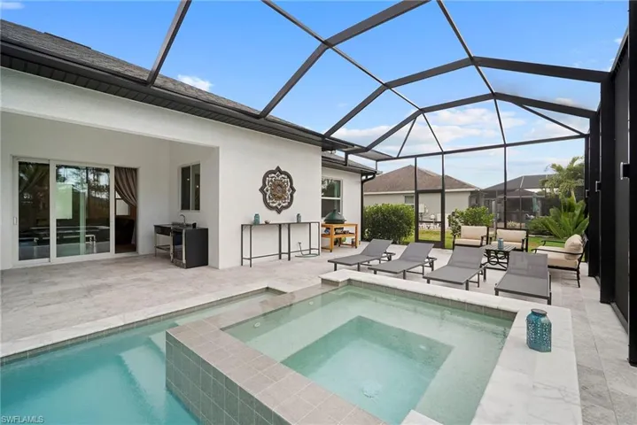 Integrated pool / hot tub featuring a sunroom, glass enclosure, and a patio