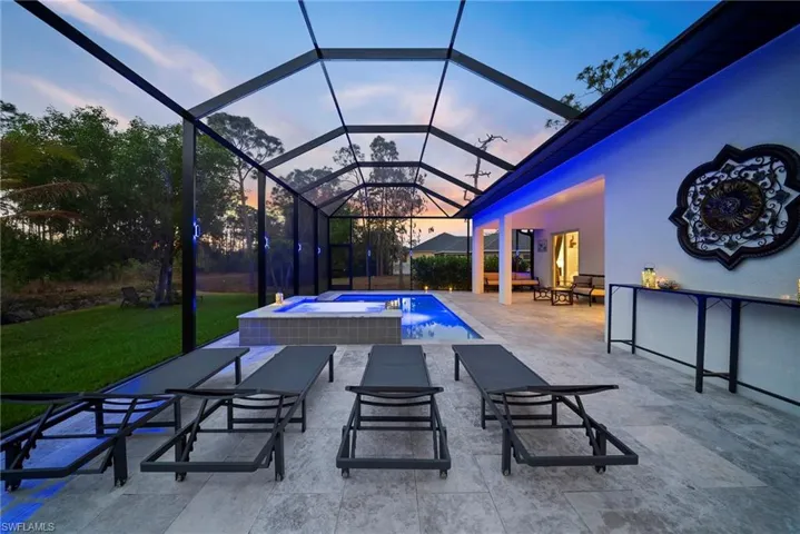 Integrated pool / spa featuring a sunroom, a patio, glass enclosure, and a lawn