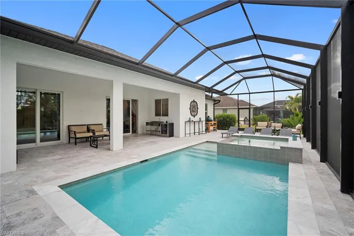 Relaxing pool / spa with a sunroom, a patio area, and glass enclosure