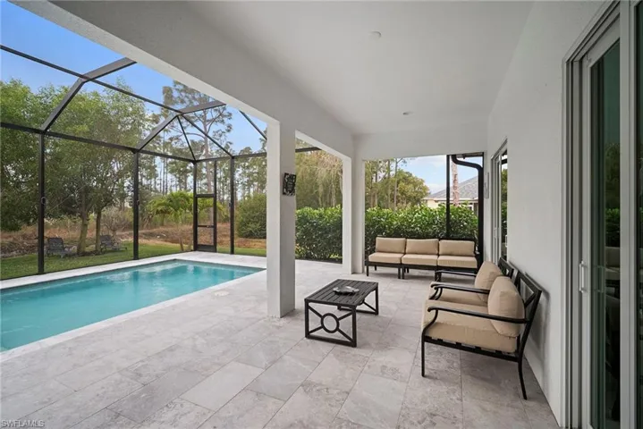 Swimming pool featuring a patio area, outdoor seating, a sunroom, and a lanai