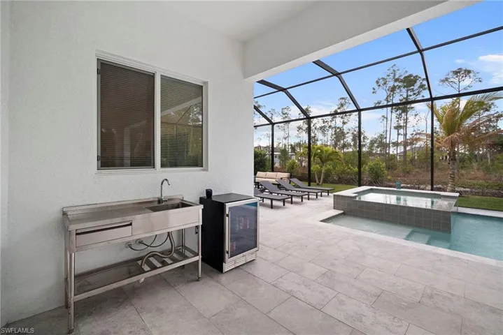 View of patio / terrace with glass enclosure, a sunroom, and a pool with connected hot tub