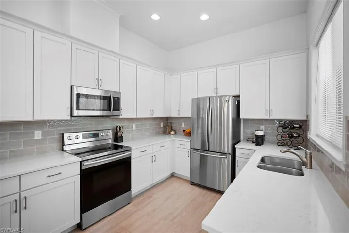 Kitchen featuring stainless steel appliances, white cabinetry, and recessed lighting