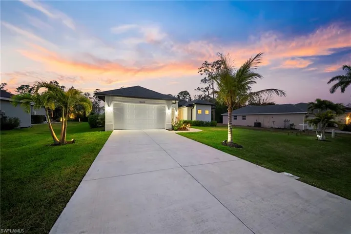 Single story home featuring a front lawn, an attached garage, and concrete driveway