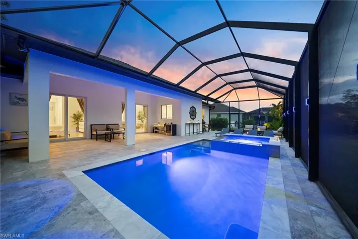 Integrated pool / spa featuring a sunroom, a patio area, and glass enclosure