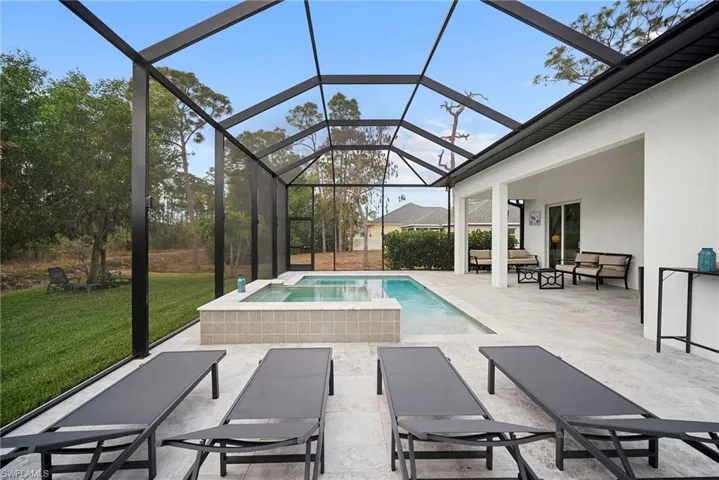 Combined pool / hot tub featuring an outdoor hangout area, a sunroom, a yard, a patio, and a lanai