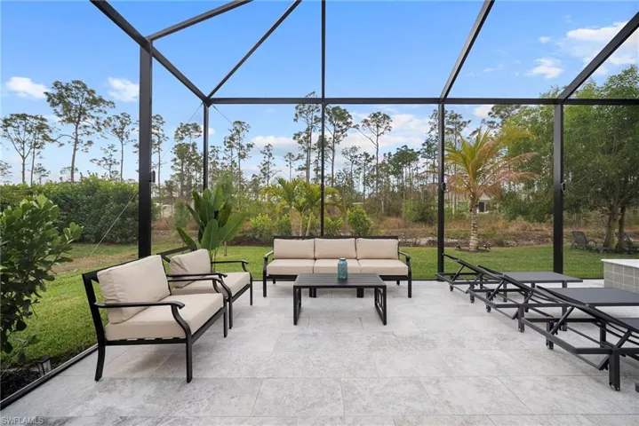 View of patio featuring glass enclosure, a sunroom, and outdoor furniture